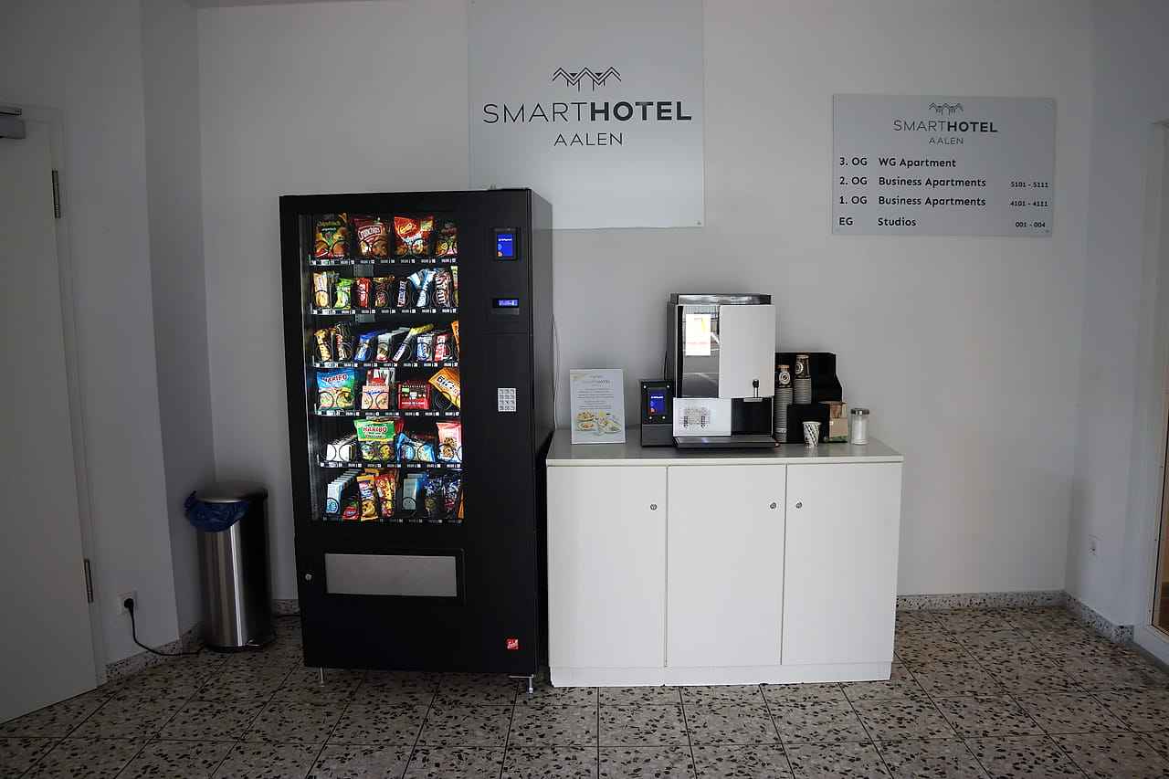 Snackautomat und Kaffeeautomat im Eingangsbereich unter dem SMARTHOTEL-Schild.