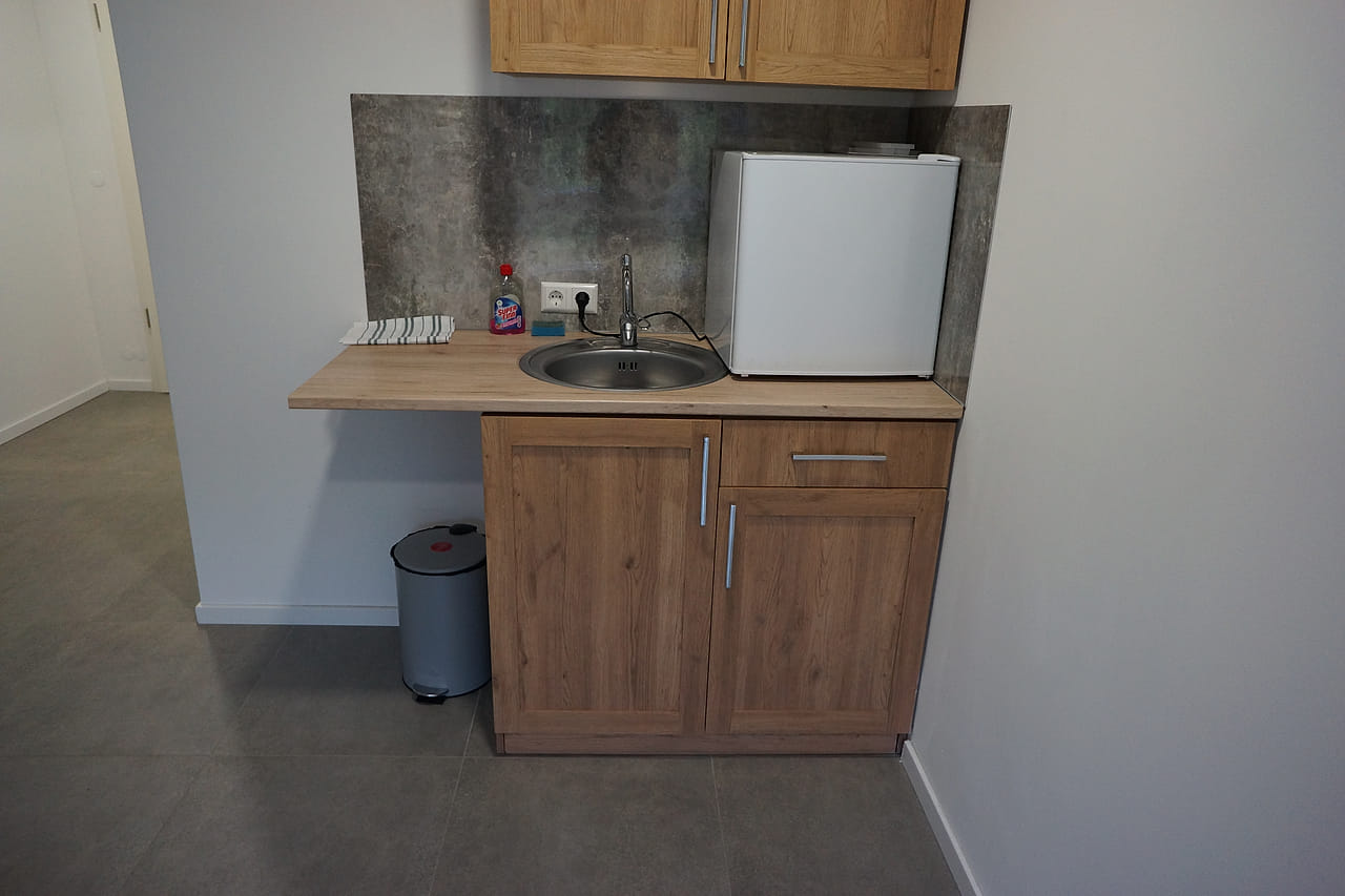 Küchenzeile mit Spüle, Kühlschrank und Mikrowelle.